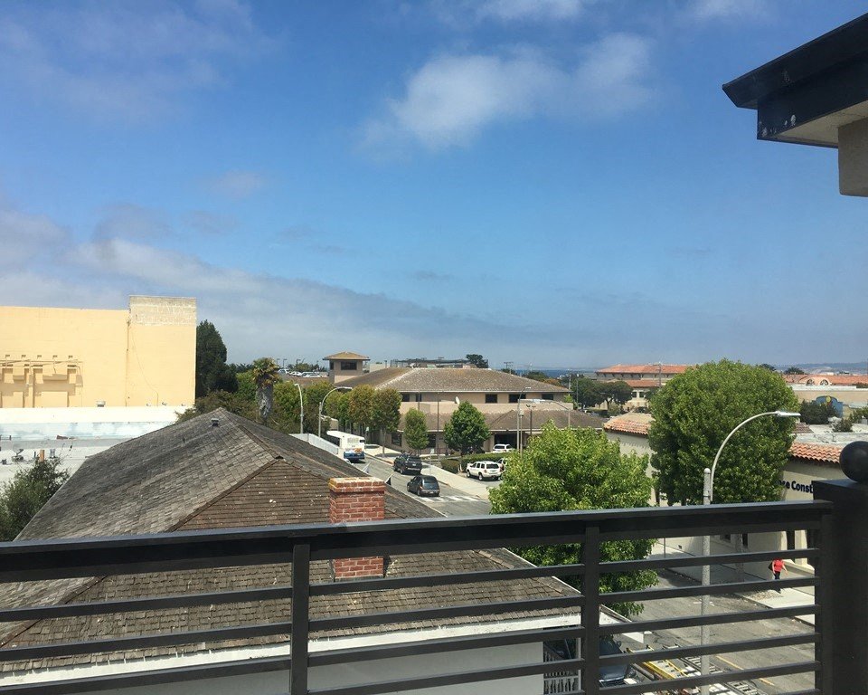 a balcony with a view of a city and a blue sky